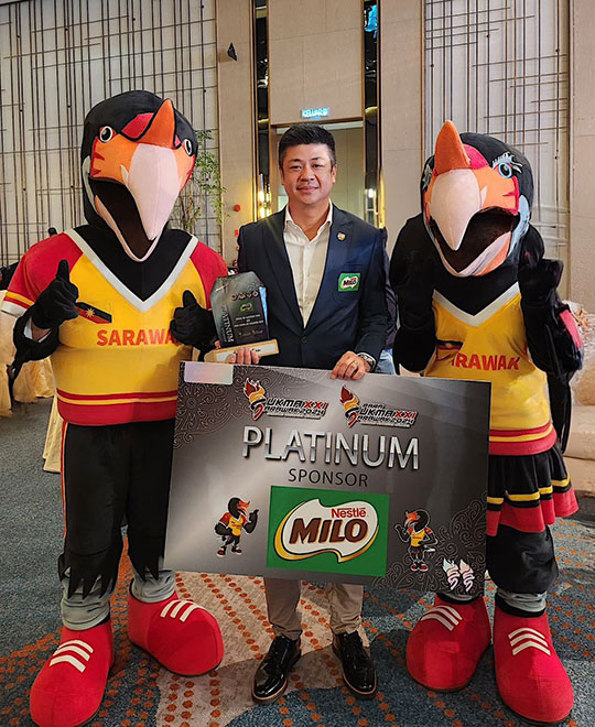 MILO® Head of Sports Marketing, standing between the official mascots for SUKMA