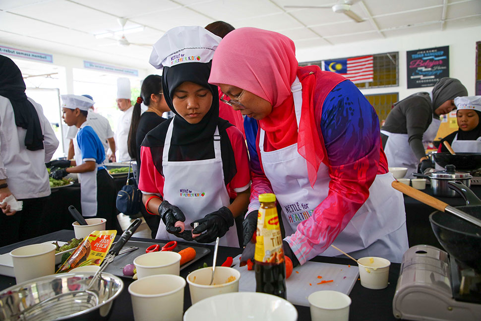Parents and children bond over cooking at the N4HK PARENPRO event, learning the importance of preparing nutritious meals together.