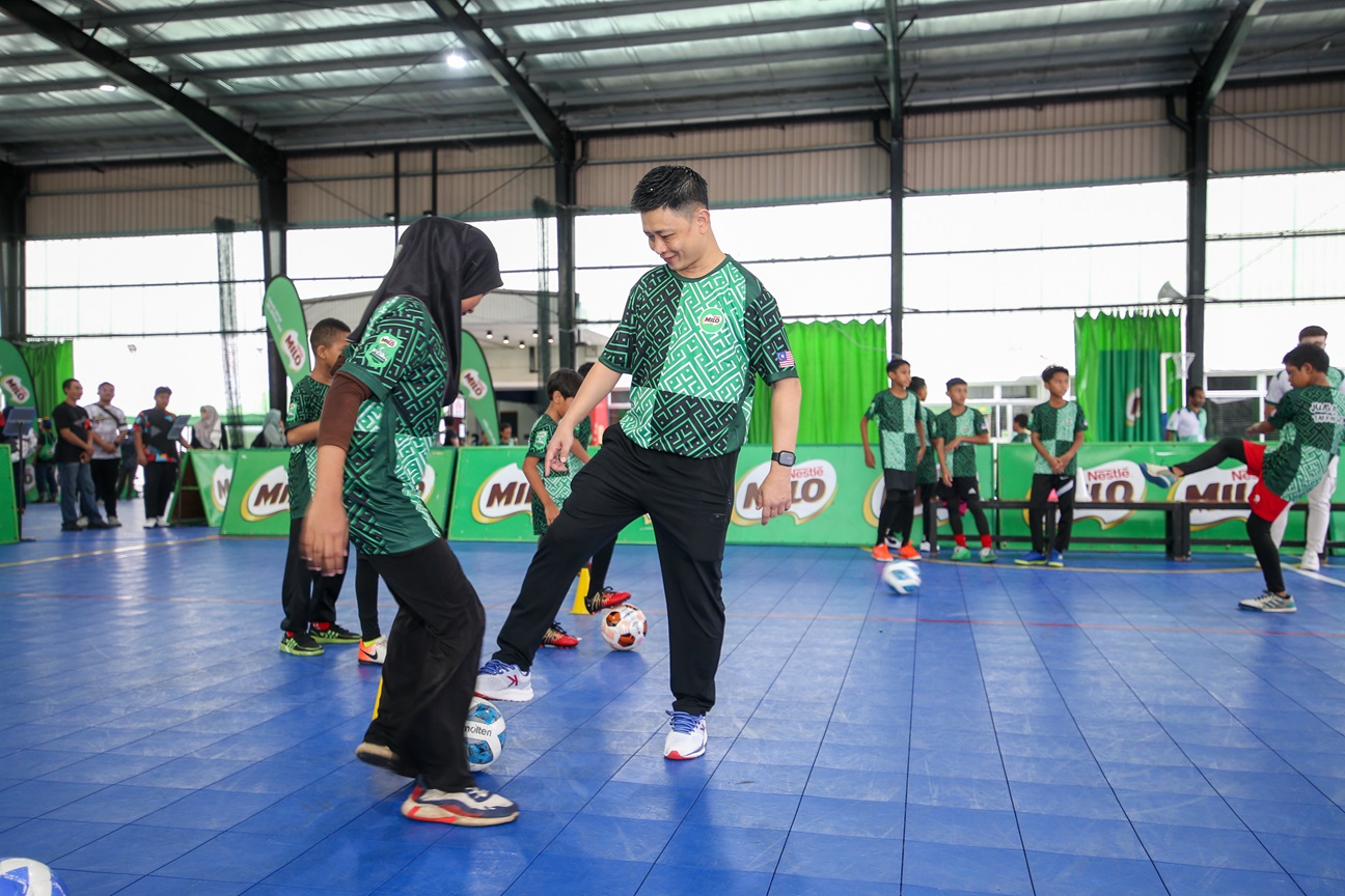 Coach Yong and children warming up with futsal drills on the court