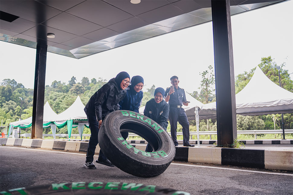 Students worked together to flip a 40kg tyre printed with negative words
