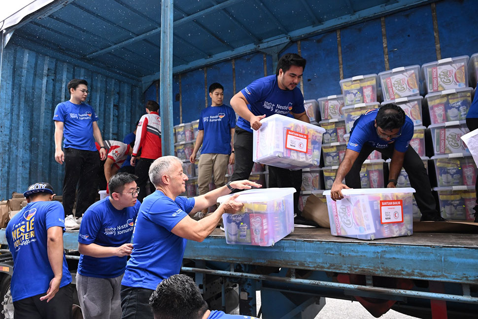 Juan Aranols, CEO of Nestlé Malaysia, and other Nestlé volunteers loading packed food aid boxes onto lorries