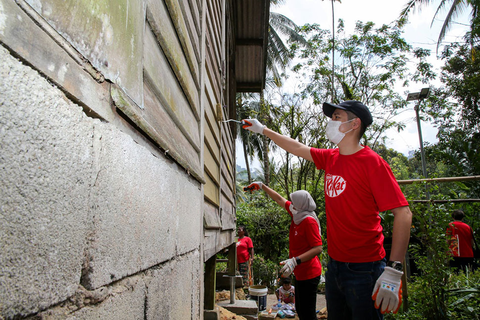 Volunteers painting the house of Orang Asli.