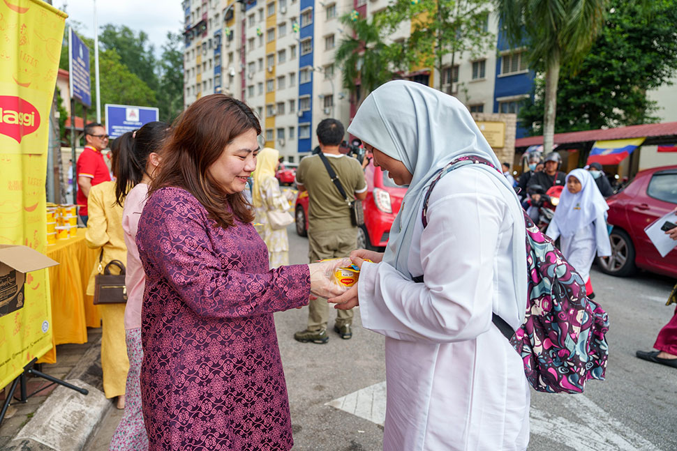Ivy Tan distributing MAGGI Bubur Lambuk